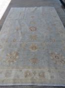 A large woollen rug in pale blue and cream ground measuring approx 203 x 291cm.