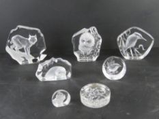A quantity of Mats Jonasson crystal paperweights together with a Dartington paperweight.
