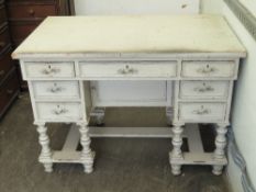A kneehole desk comprising central drawer flanked by further drawers to each side,
