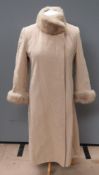 A felted woolen coat with faux fur collar and sleeves, labels having been removed,