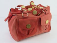 Ted Baker; a coral suede handbag having floral lining, approx 30cm wide.