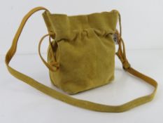 A yellow suede leather bucket style handbag by Urban Outfitter, approx 16cm wide.