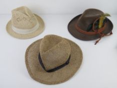 A contemporary straw trilby together with another similar and a souvenir type Swiss Alps hat.