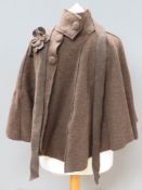 A brown 85% wool cape having flower applique upon.