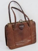 A vintage reptile skin leather handbag having suede lining, mirror within, 23 x 17cm.
