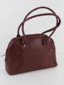 A vintage burgundy leather handbag marked for Gucci, unauthenticated, approx 30cm wide.