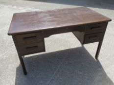 A mid 20th century oak kneehole desk by Abbess having twin drawers to each side and raised over