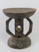 A hand carved and ebonised wooden stool of African origin and measuring 28.5cm dia, 32cm high.