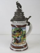 A military themed ceramic beer stein having pewter lid with horned goat upon, of German manufacture.