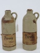 Two stoneware bottles bearing labels for Parsnip Wine and Birch Wine, each standing 24cm high.