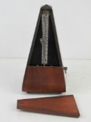 A late 20thC pyramidal mahogany cased clockwork metronome standing approx 22cm high. Full working