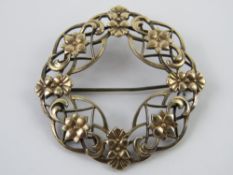 A Symmetalic Sterling silver and 14ct gold brooch of wreath form decorated with flowers, 4.5cm dia.
