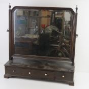 A large Edwardian toilet mirror having bevel edged glass on H shaped frame raised over three