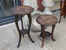 Two relief carved black forest type occasional tables raised over three supports with solid under-