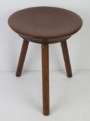 A smart early 20thC turned mahogany three legged milking stool as made by Ludestons, Albert