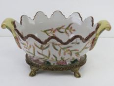 A hand painted ceramic basket style centrepiece bowl raised over brass stand and decorated with