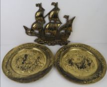 A brass wall hanging decoration in the form of a ship approx 38cm wide, and a pair of embossed brass