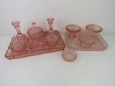 Two early 20thC pink cut glass dressing table sets.