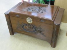 An early 20thC Oriental hardwood camphor chest having finely detailed relief decoration upon to