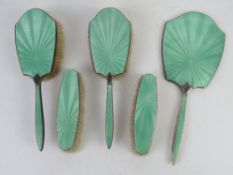 A HM silver guilloche engine turned enamel dressing table set comprising hand mirror,