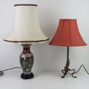 A brass table lamp raised over three outswept legs and having silk shade all standing 47cm high,