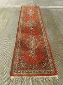 An orange ground Persian runner measuring 320 x 80cm.