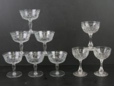 A set of six etched glass champagne saucers together with a set of three cut glass champagne