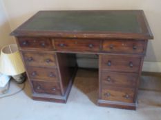 A Victorian leather topped kneehole desk having central drawer flanked by further drawers to each