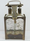 A 20thC brass framed musical Tantalus having key to base (currently over-wound), believed to play