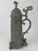 A late 19thC pewter lidded beer stein dated 5th July 1899, having winged mermaid style feet and