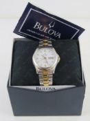 A Bulova stainless steel wristwatch having skeleton back, white dial with day and date apertures, in