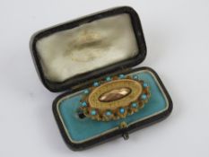 A delightful Victorian brooch set with turquoise and having glazed mourning locket panel to back,