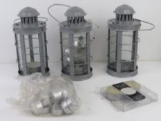 A set of three contemporary storm lanterns with a quantity of tea lights.