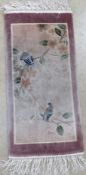 A prayer mat type rug decorated with birds and flowers measuring approx 63 x 30cm.