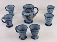 A hand painted Portuguese design c1962 themed jug and cup set in blue glaze having floral decoration