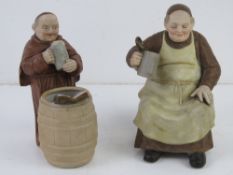 Two bisque figurines of beer making monks.