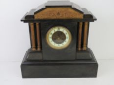 A late 19th century polished slate architectural mantel clock, enamelled chapter ring with Roman