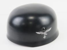 A reproduction WWII German single decal M38 Fallschirmjager helmet with liner and chin strap.