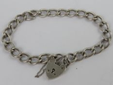 A HM silver curb link chain charm bracelet having heart padlock clasp,
