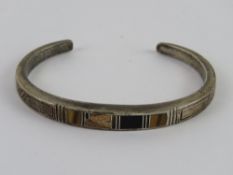 To match above lot; a Sterling silver Native American bangle set with tiger's eye,