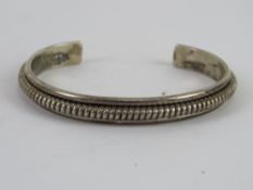 A Native American sterling silver bangle marked for Tahe, 19.9g.