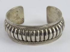 To match above lot; a Native American sterling silver bangle having maker's mark JM upon weighing