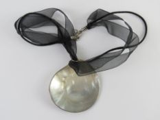 A mother of pearl pendant on ribbon necklace having 925 silver clasp.
