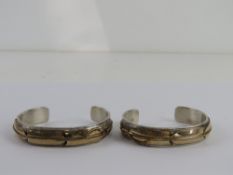 A pair of Sterling Silver Native American bangles by Lee Bennett having 12ct gold plated feather