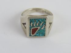A sterling silver Native American signet ring set with crushed turquoise is bear paw design,