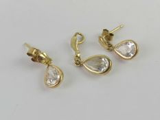 A suite of jewellery comprising earrings and pendant, white teardrop shaped stones,