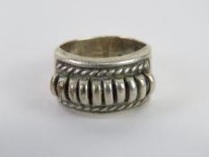 A Native American ring in unmarked white metal having designer mark T C upon, size O, 9.44g.
