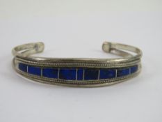 A Native American sterling silver lapis lazuli set bangle bearing maker's mark T B, 14.7g.