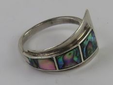 A silver abstract design ring having graduated Abalone shell panels upon, stamped 925, size R-S.