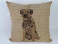 A throw cushion having terrier upon.